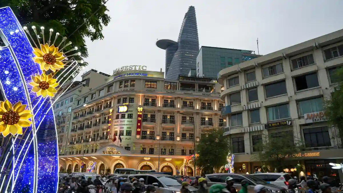 Evening rush hour traffic in front of Hotel Majestic Saigon with Bitexco Financial Tower in the background, District 1, Ho Chi Minh City
