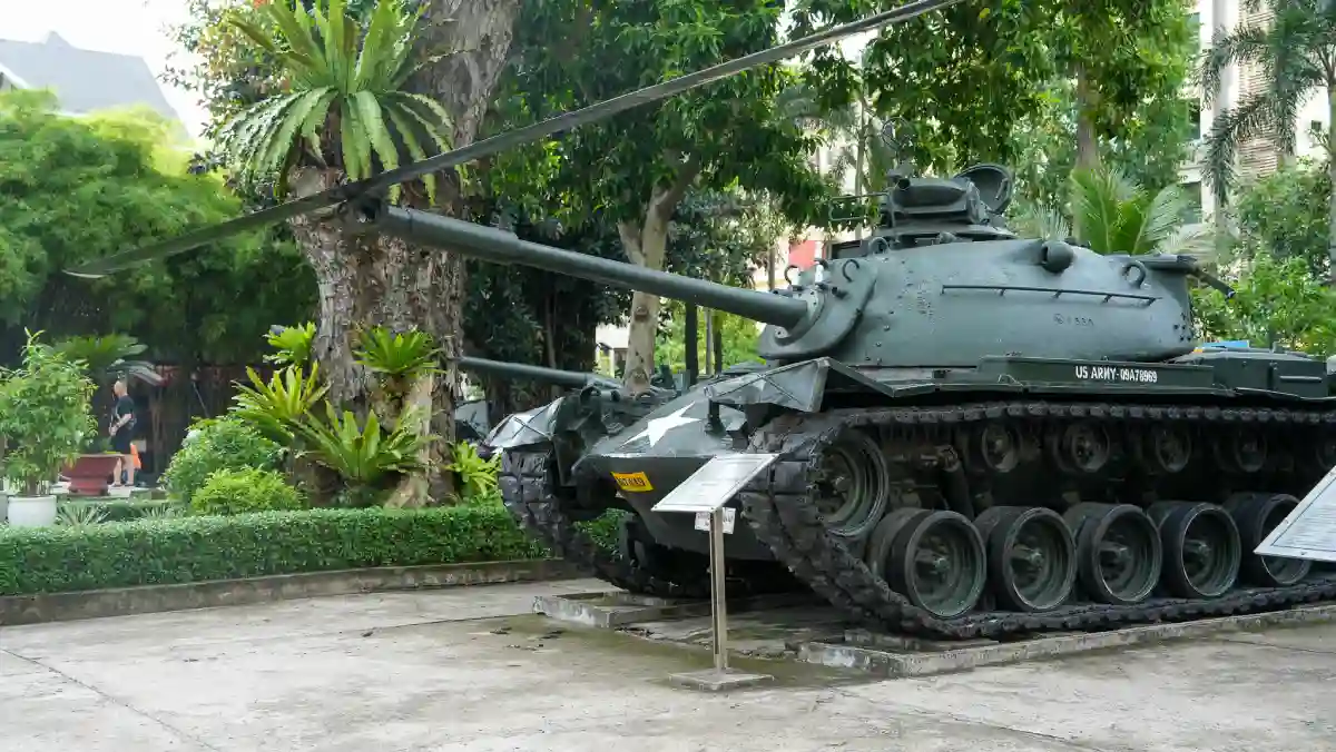 US Army M41 Walker Bulldog tank with white star markings on display under tropical trees in the outdoor military collection at the War Remnants Museum, Ho Chi Minh City