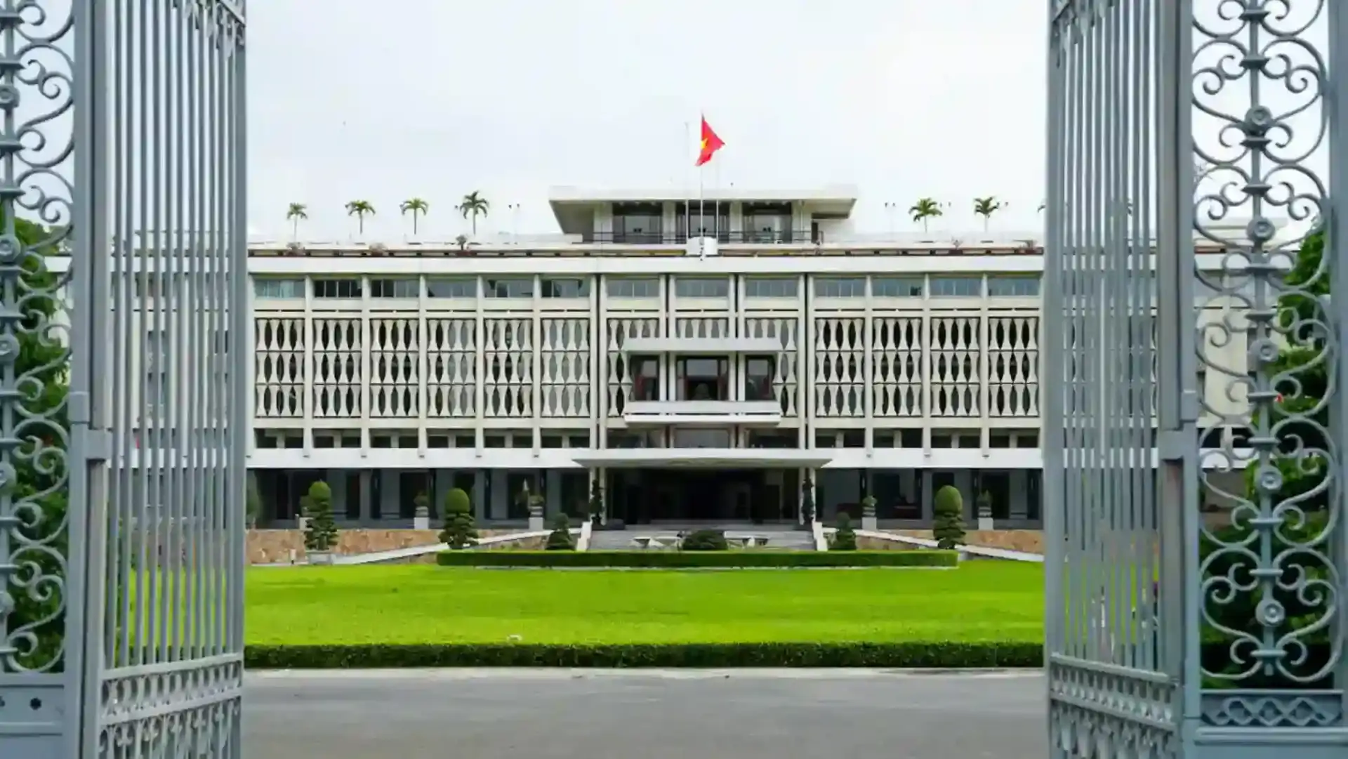 Independence Palace viewed across its expansive front lawn through the open main gates in District 1, Ho Chi Minh City