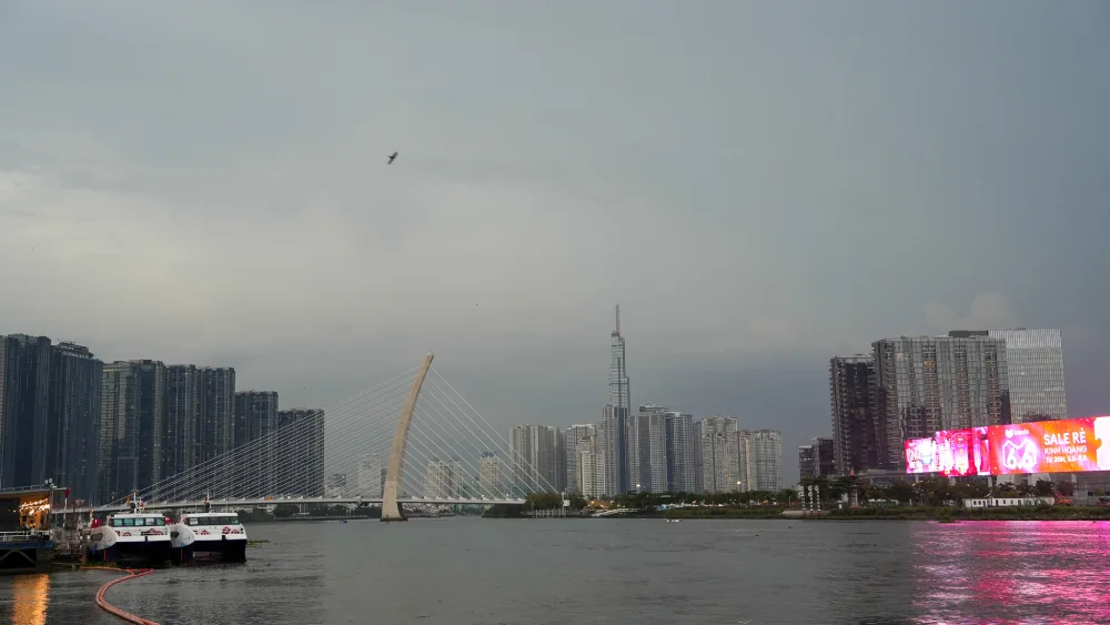 View from Bach Dang Wharf across the Saigon River at dusk, with Landmark 81 tower and the Thu Thiem cable-stayed bridge rising above the Thu Thiem skyline