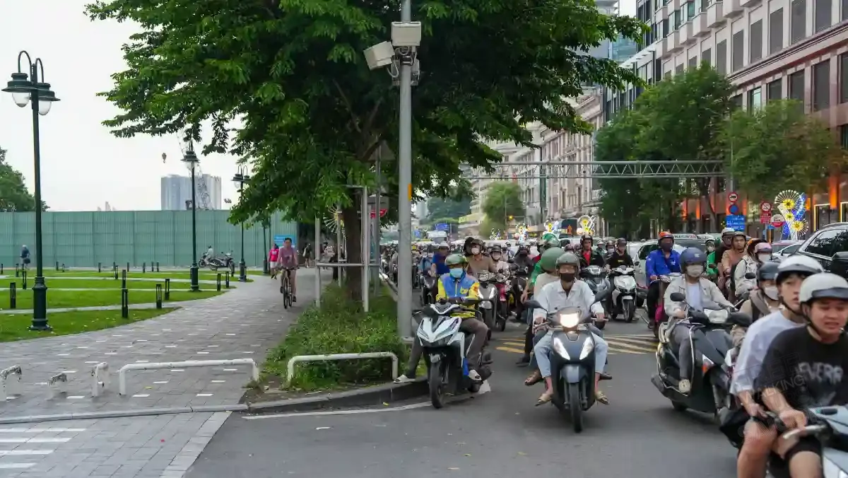 Evening rush hour near Bach Dang Wharf in Saigon — a dense river of motorbikes flowing past office towers in District 1