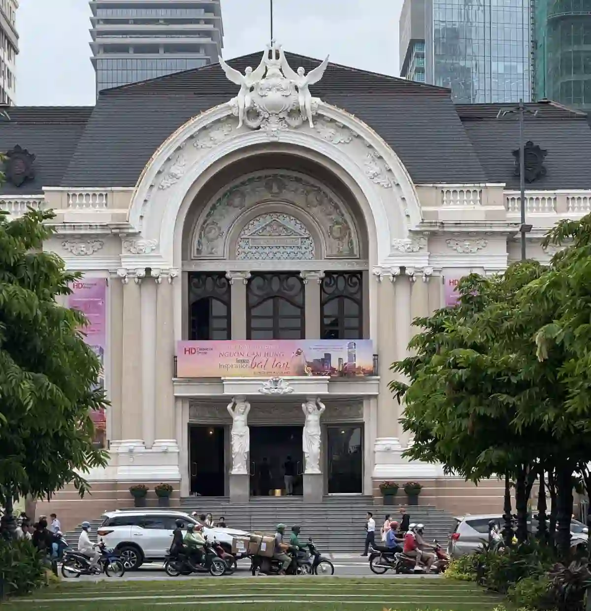 Saigon Opera House front façade — Beaux-Arts arched entrance with twin caryatid statues, ornate stone reliefs and slate roof on Lam Son Square in District 1, Ho Chi Minh City