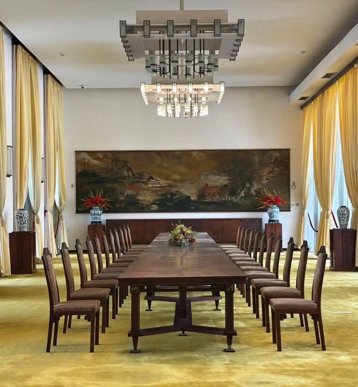 Cabinet meeting and banquet hall inside Independence Palace with long wooden table, tall chairs and modernist chandeliers