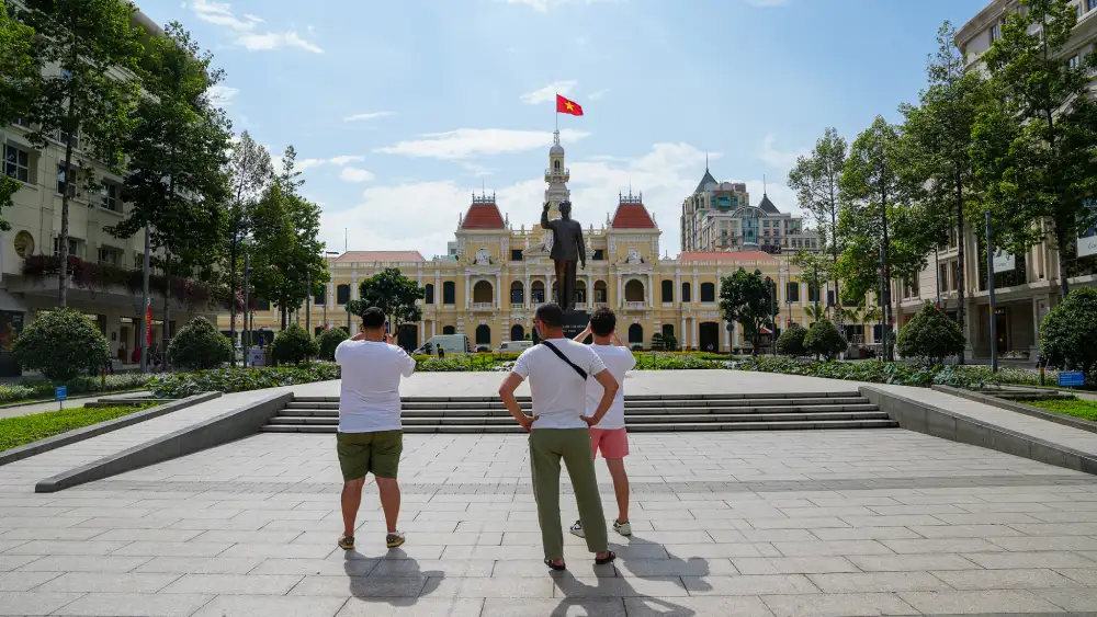 Guests taking photos in front of Ho Chi Minh City Hall and the Ho Chi Minh statue on Nguyen Hue plaza, District 1, Saigon