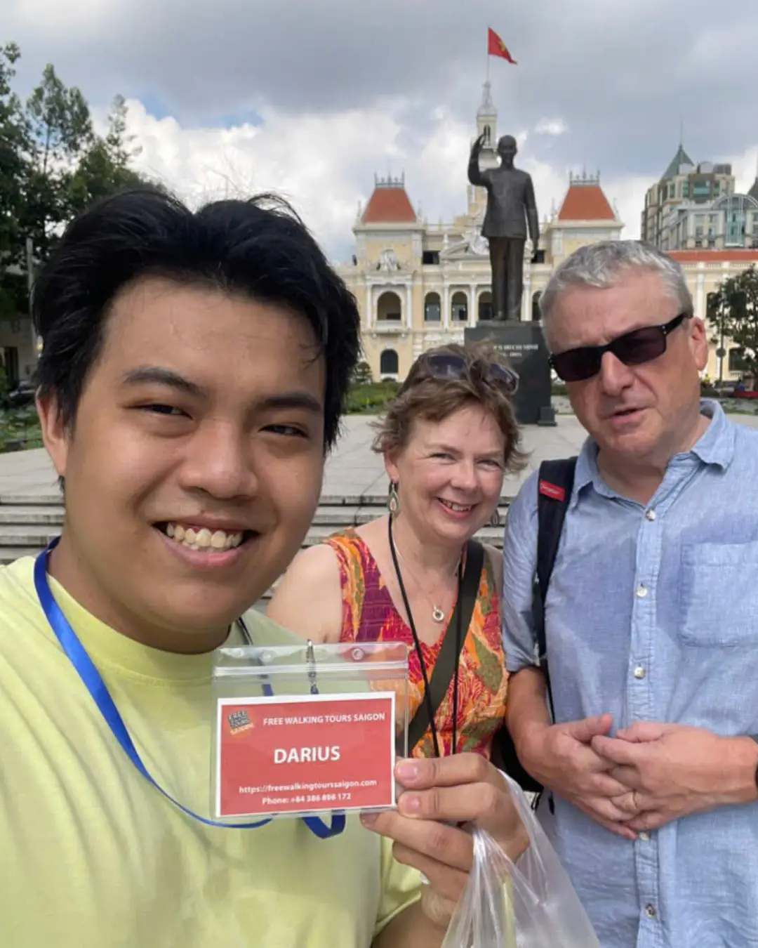 Saigon local guide Darius with travellers in front of Ho Chi Minh City Hall.