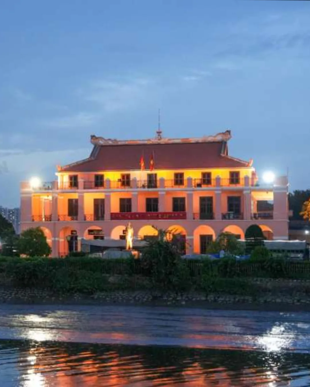 Travellers and a local guide at Bach Dang Wharf with the Saigon River skyline at dusk — Real Moments From Saigon