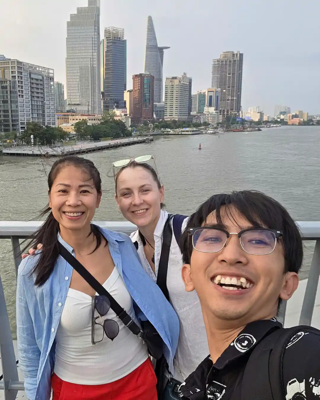 Travellers and a local Saigon guide with the Saigon River and city skyline in the background.